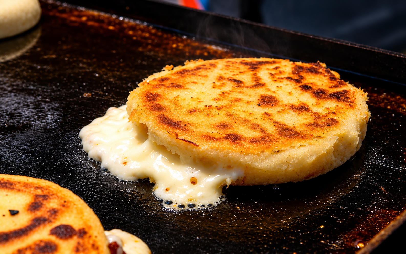 Arepa colombiana dorándose en la plancha